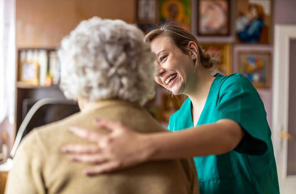 A small group of seniors of diverse backgrounds smiling while participating in a community activity indoors.