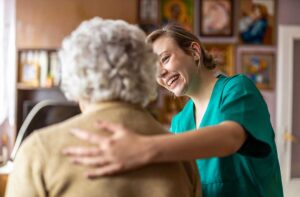 A small group of seniors of diverse backgrounds smiling while participating in a community activity indoors.