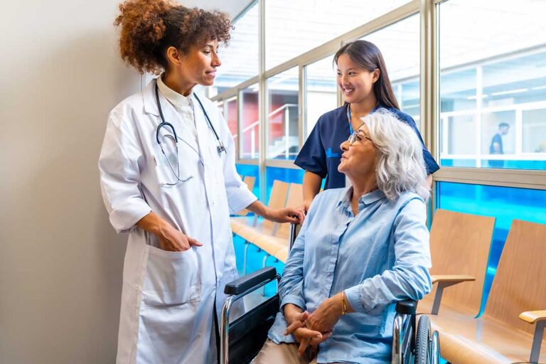 Older adult speaking with a caregiver in a bright assisted living lounge